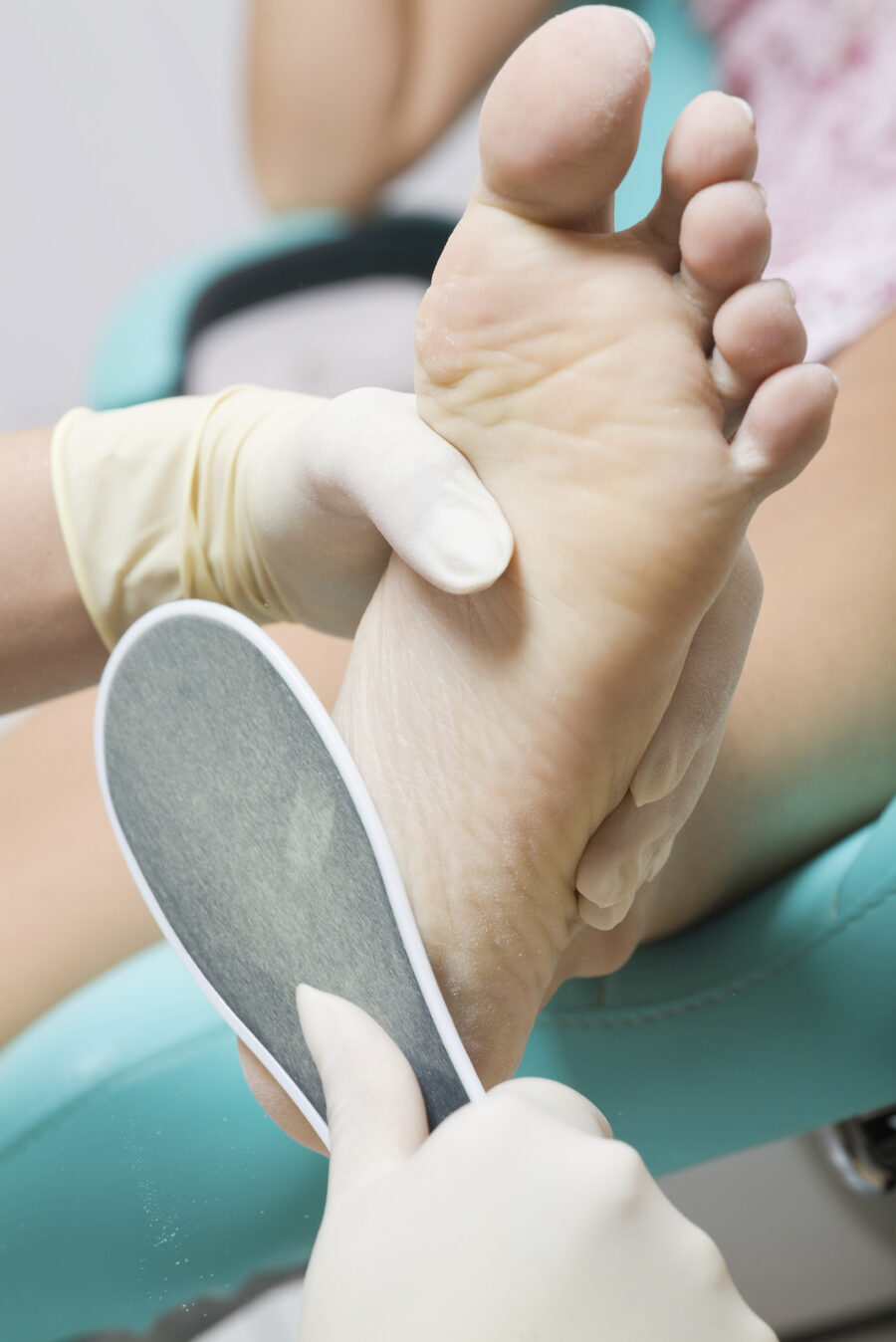 Podiatrist treating the sole of a patient's foot